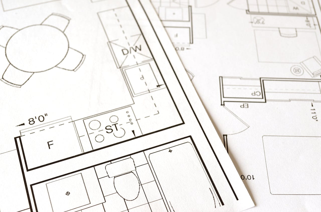 why-choose-us Close-up view of an architectural floor plan on paper showcasing detailed room layouts and measurements.
